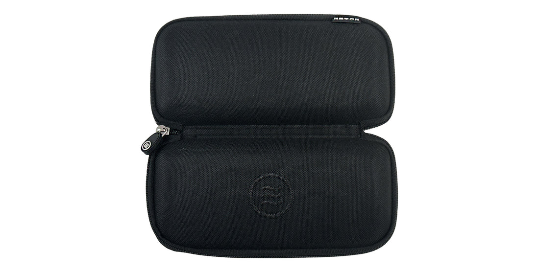 Lay-down of opened black clamshell slim hard case showing zippered closure and embossed tilde logo on textured waterproof polyester