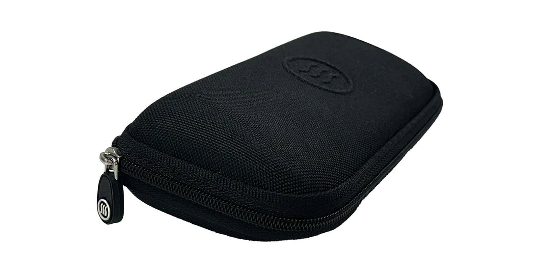 Three-quarter view of Slim Hard Case showcasing black zippered polyester exterior and embossed Tilde logo on white background