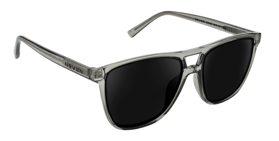 Three-quarter close-up of Rip Tide prescription sunglasses with translucent cool-gray frame, dark sunglass lenses, and NEVEN logo on the temple on white background