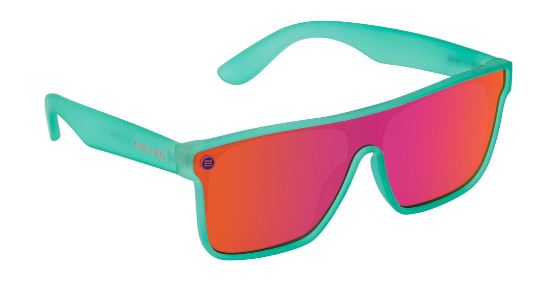 Close-up of X sunglasses showing transparent teal frame and pink polarized uni-lens with stainless steel logo on white