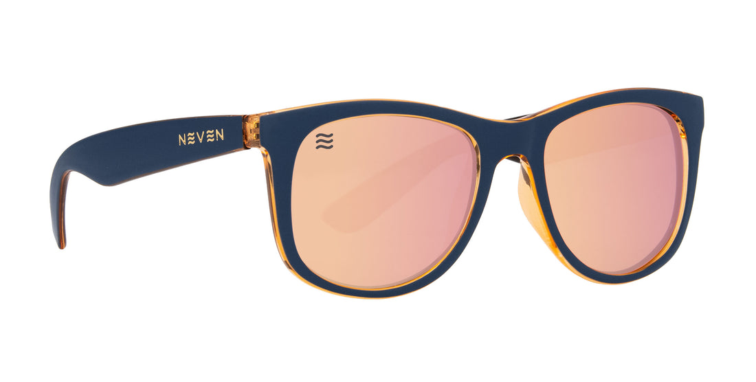 Right side close up of Sundown polarized sunglasses with navy matte frame, amber interior and pink mirrored lenses on white