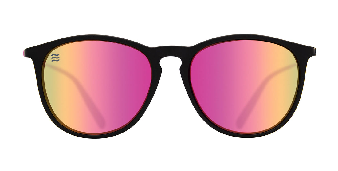 Front view of Quinn sunglasses showcasing black matte frame and pink mirrored polarized lenses on white background