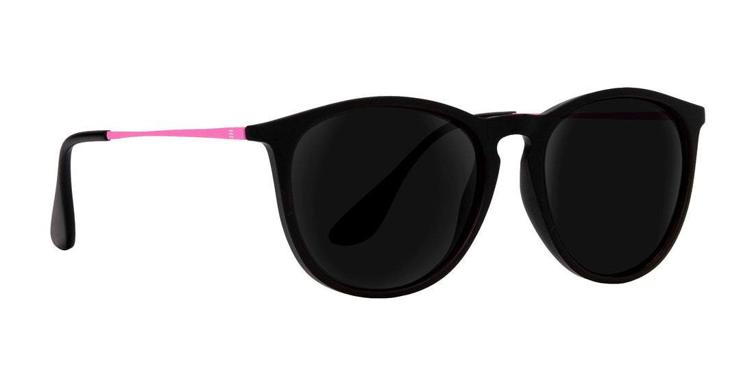 Close-up front view of Quinn prescription sunglasses showing black round TR90 frame with matte pink temples on white background